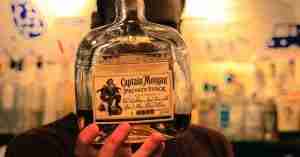 An image of a man holding a bottle of Captain Morgan