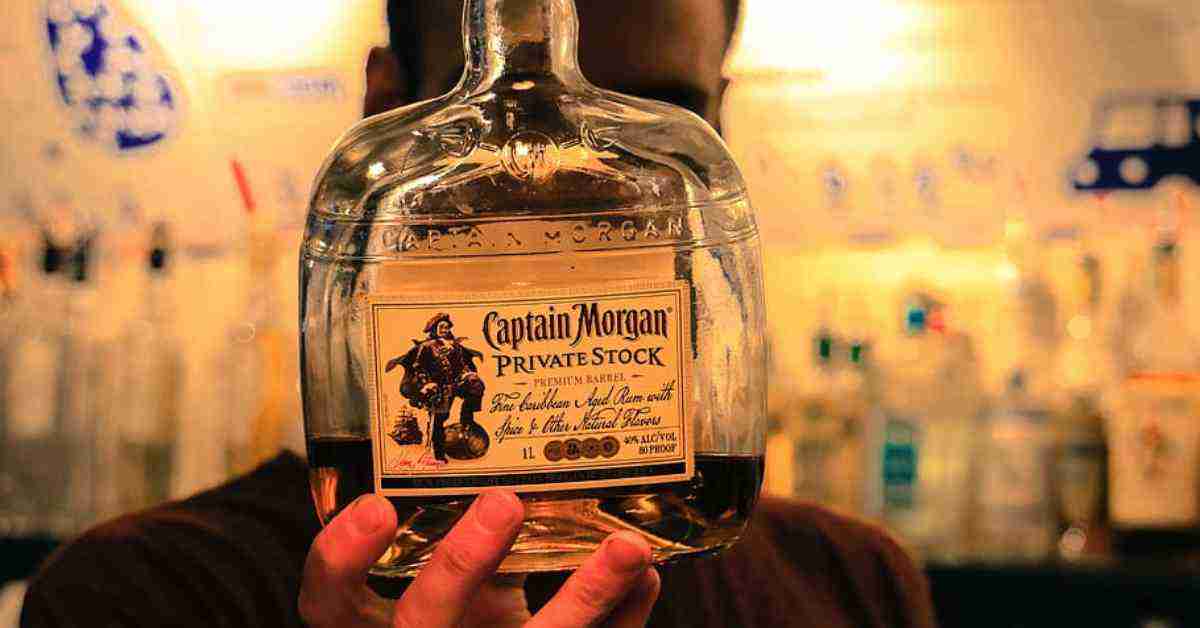 An image of a man holding a bottle of Captain Morgan