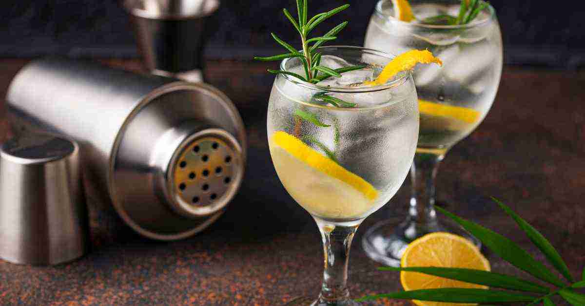 A pair of gin glass filled with gin with lime