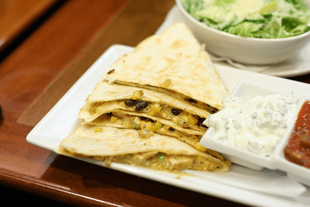 A plate of gluten-free quesadillas with jalapeno dip on side