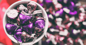 Are Hershey's Kisses Gluten-Free? An image of a cup full of Hershey's Kisses with a bunch on the background