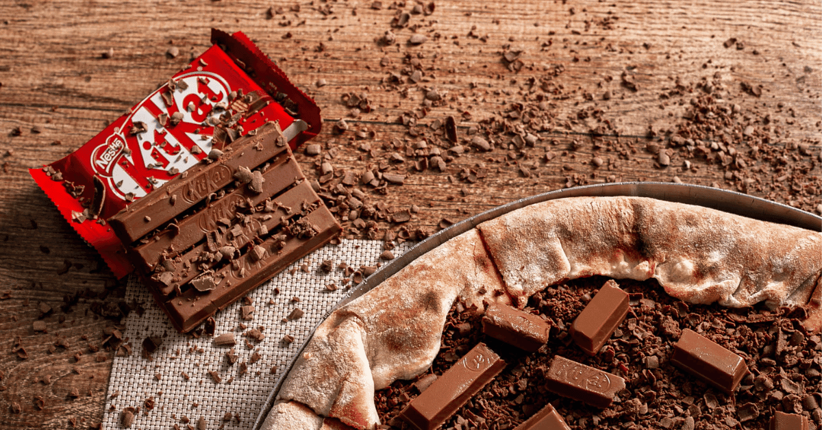 Are Kit Kats Gluten-Free? An image of KitKat Chocolate on a woody surface with shredded chocolates