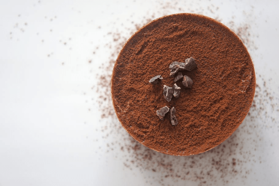 An image of cocoa powder with cocoa beans