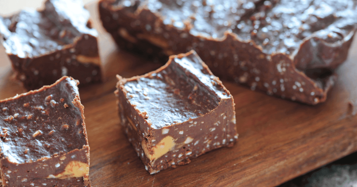 Is Fudge Gluten-Free? An image of chocolate fudge with nuts on a wooden cutting board