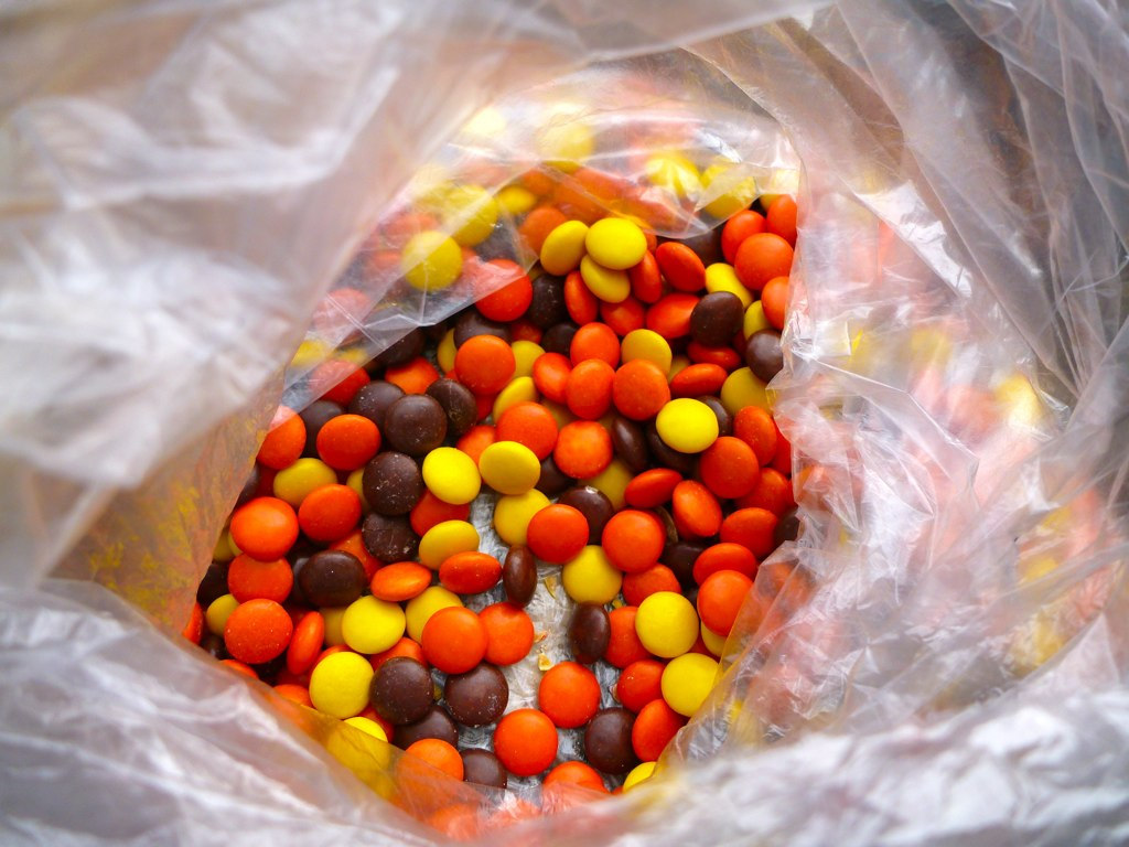 A plastic with bunch of Reese's Pieces